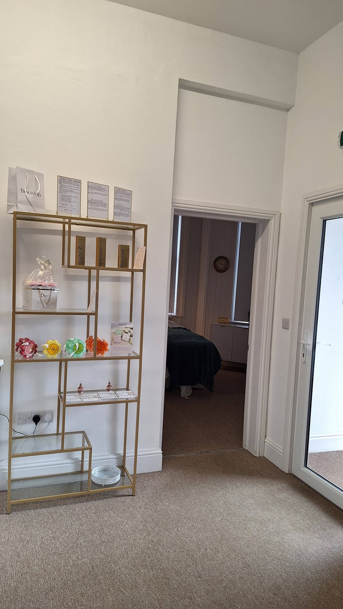 Gold ladder shelving displaying BeautyLab London skincare products and certificates.